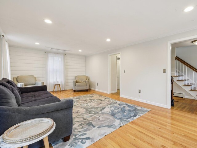 living room featuring baseboard heating, wood finished floors, stairs, recessed lighting, and baseboards