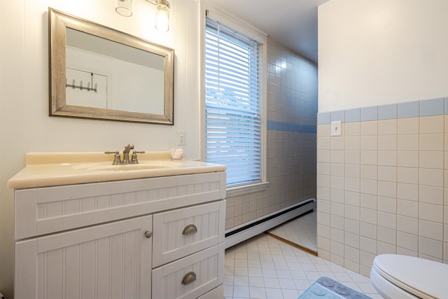 bathroom with a baseboard radiator, tile walls, tile patterned flooring, toilet, and vanity