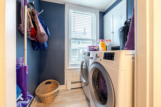 laundry area with separate washer and dryer, a baseboard radiator, wood finished floors, and plenty of natural light