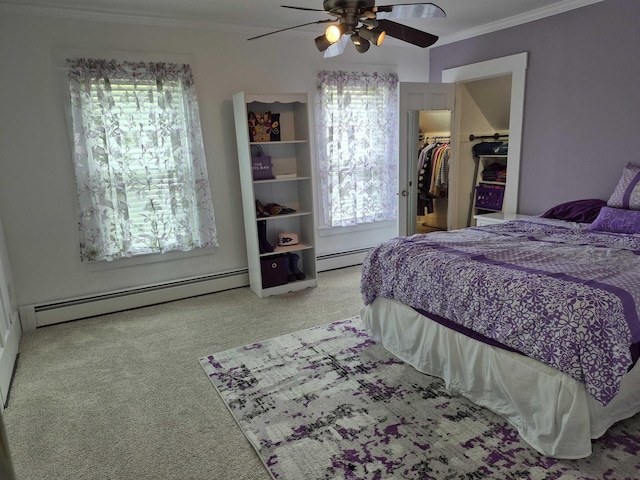 carpeted bedroom with a baseboard radiator, crown molding, a spacious closet, a ceiling fan, and a closet