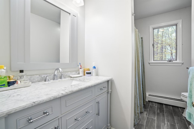 15 Roosevelt Dr, Bedford, NH 03110 - full bathroom with baseboard heating, vanity, toilet, wood tiled floors, and baseboards