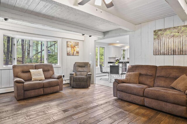 15 Roosevelt Dr, Bedford, NH 03110 - living room featuring hardwood / wood-style floors, beam ceiling, ceiling fan, wood walls, and baseboard heating