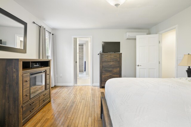 15 Roosevelt Dr, Bedford, NH 03110 - bedroom with light wood-style floors, a wall mounted air conditioner, baseboards, and connected bathroom