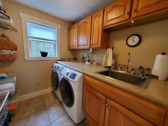 laundry room featuring cabinet space, washer and dryer, light tile patterned floors, and baseboards