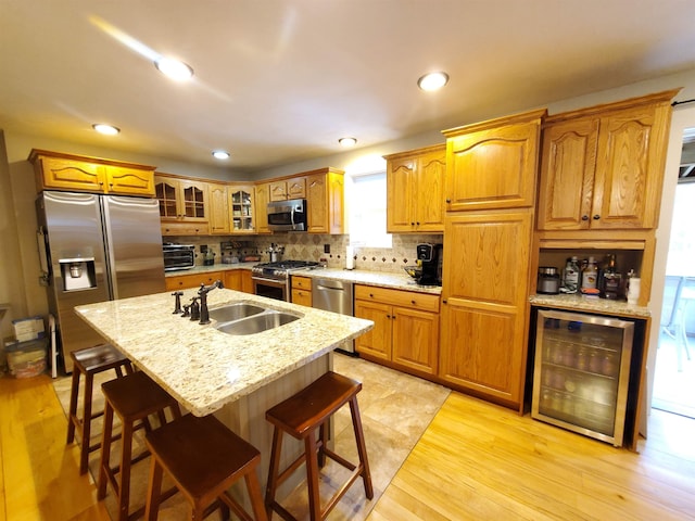 kitchen with stainless steel appliances, a sink, wine cooler, decorative backsplash, and glass insert cabinets