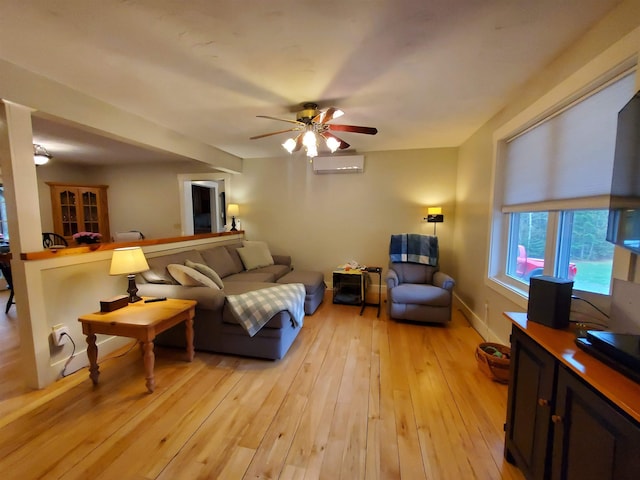 living room with light wood-style flooring, ceiling fan, and a wall mounted AC