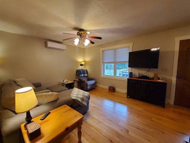 living area featuring an AC wall unit, ceiling fan, light wood finished floors, and baseboards