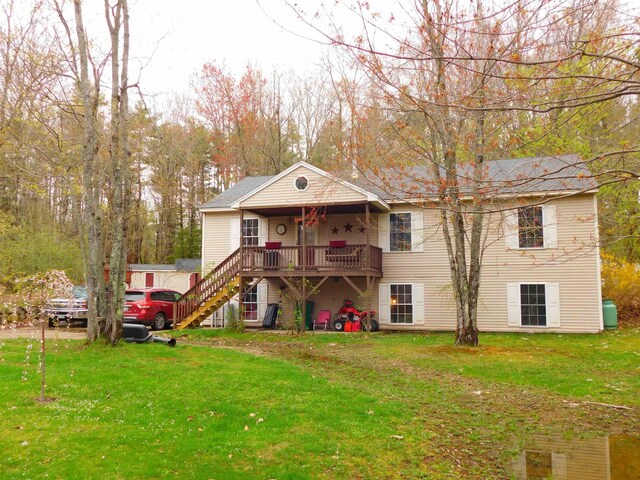 rear view of house featuring stairs and a lawn
