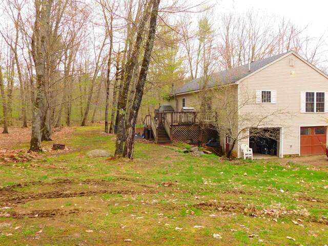 view of yard featuring stairway, a wooden deck, and a garage