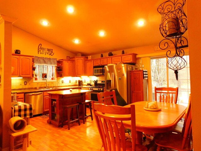 dining space with lofted ceiling, recessed lighting, and light wood-style floors
