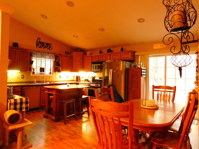 dining area with vaulted ceiling, recessed lighting, light wood finished floors, and healthy amount of natural light