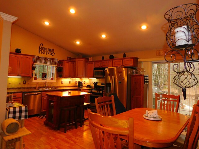dining room featuring vaulted ceiling, light wood finished floors, and recessed lighting