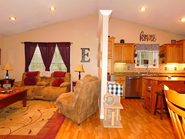 living room with vaulted ceiling, light wood-style floors, and recessed lighting