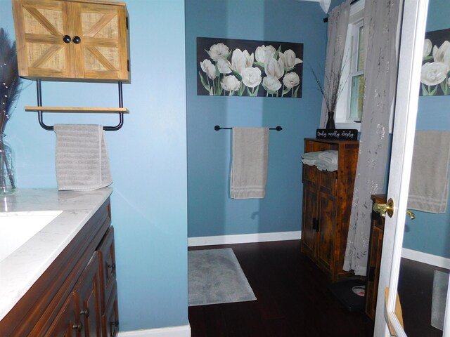 bathroom with vanity, baseboards, and wood finished floors