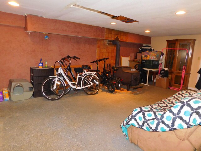 finished basement featuring a wood stove and recessed lighting