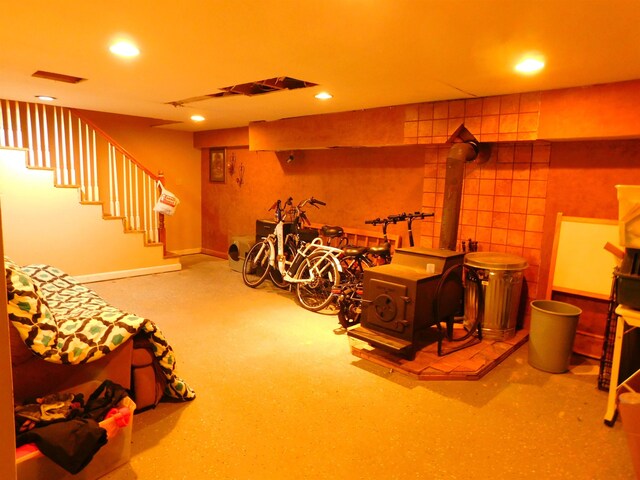 finished below grade area with recessed lighting, stairs, carpet floors, and a wood stove