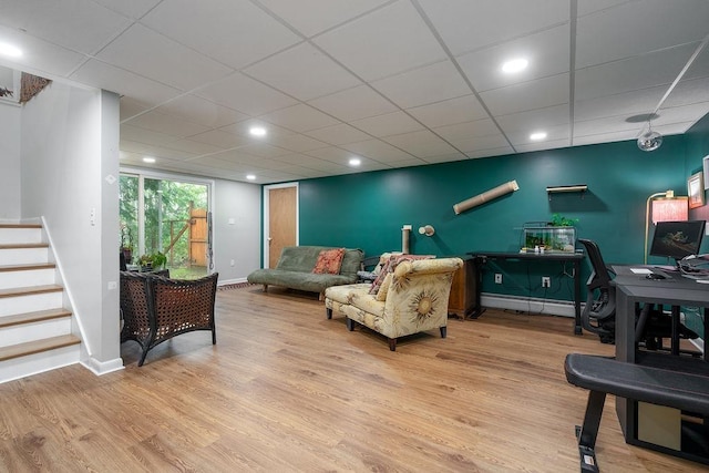 113 Watchtower Rd, Hopkinton, NH 03229 - living room with wood finished floors, a baseboard heating unit, baseboards, stairs, and a desk