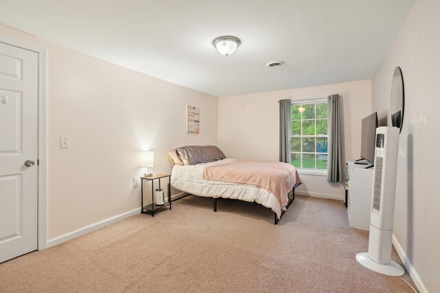 bedroom featuring light colored carpet and baseboards