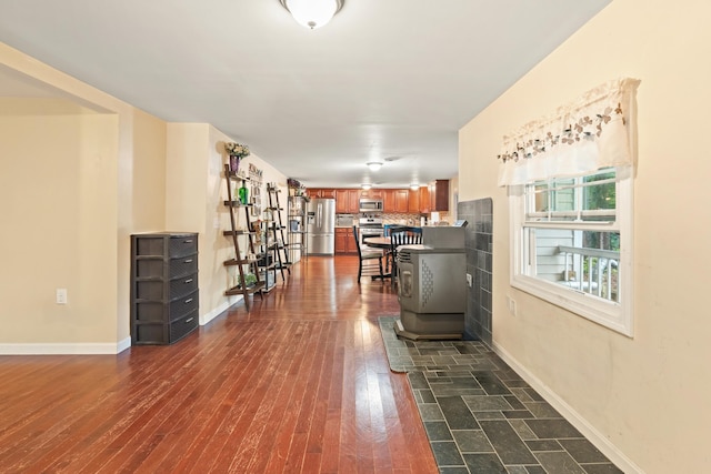 corridor featuring baseboards and dark wood-style flooring
