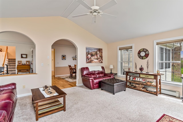 carpeted living area with a ceiling fan, vaulted ceiling, stairway, arched walkways, and baseboards