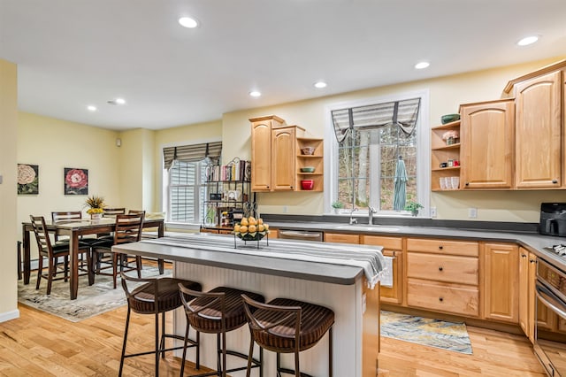 kitchen with open shelves, appliances with stainless steel finishes, a kitchen breakfast bar, light wood-type flooring, and recessed lighting