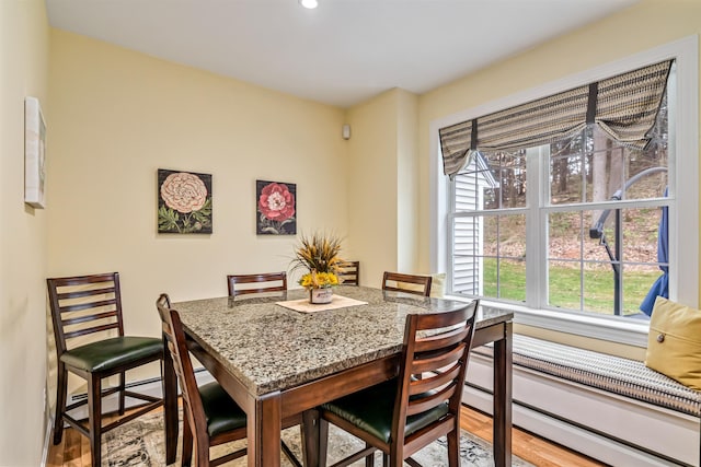 dining room featuring baseboard heating, wood finished floors, and recessed lighting