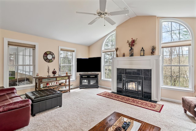 living area with carpet floors, lofted ceiling, a ceiling fan, a tile fireplace, and baseboards