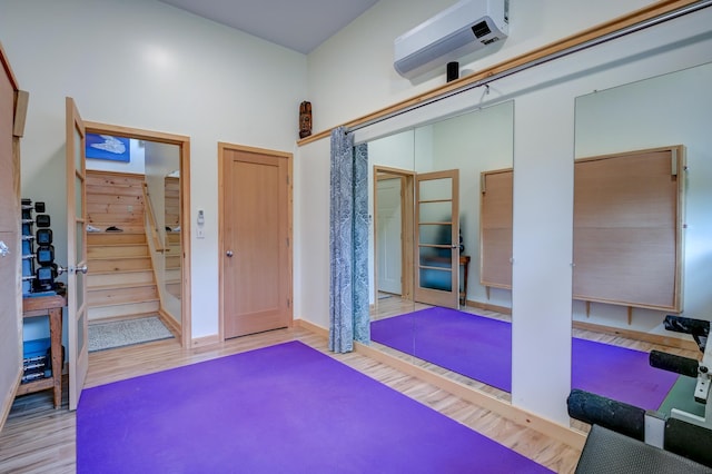 workout area featuring wood finished floors and a wall mounted AC