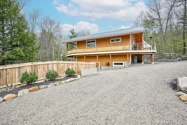 view of front of property with fence, metal roof, and a wooden deck