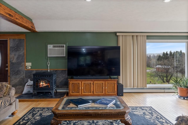 331 Gilman Rd, Sheldon, VT 05450 - living area featuring a wall mounted AC, wood-type flooring, a baseboard heating unit, a wood stove, and beam ceiling