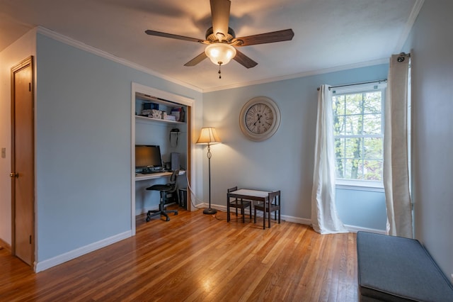 office space featuring wood-type flooring, a ceiling fan, crown molding, and baseboards