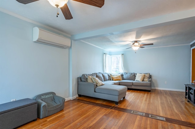 living room with ceiling fan, a wall unit AC, wood-type flooring, crown molding, and baseboards