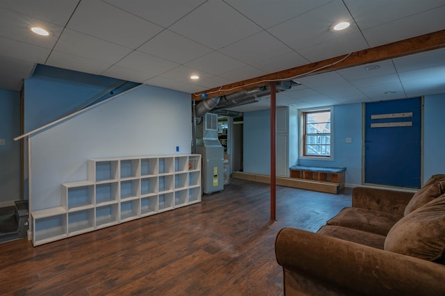 below grade area featuring wood finished floors, heating unit, baseboards, and recessed lighting