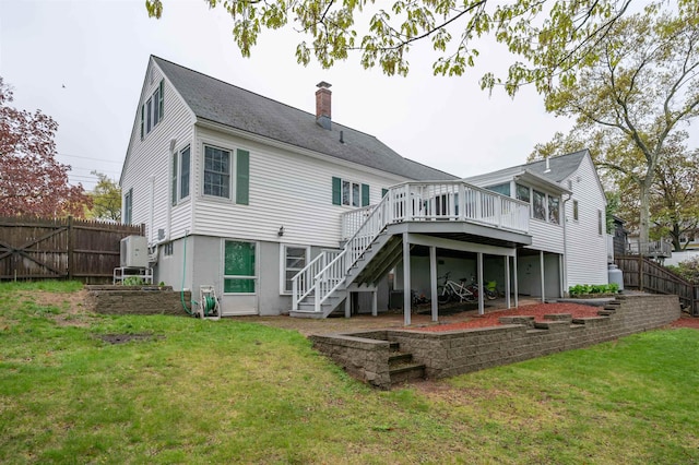 back of property featuring stairs, a wooden deck, and a chimney