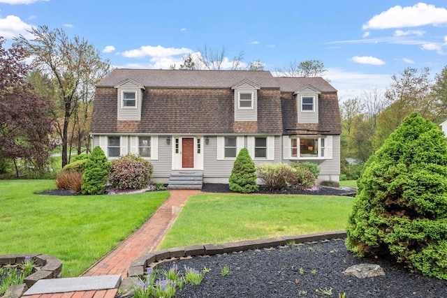dutch colonial featuring a gambrel roof, roof with shingles, and a front yard