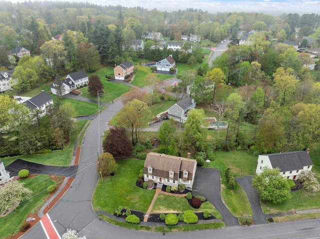 aerial view of property's location featuring a heavily wooded area and nearby suburban area