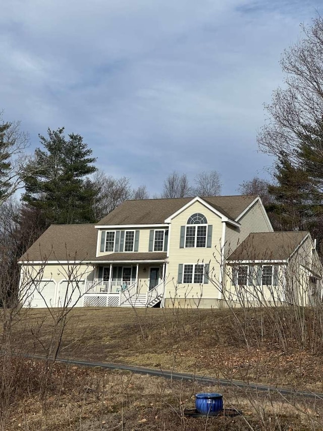 view of front of property with covered porch, fence, and a shingled roof