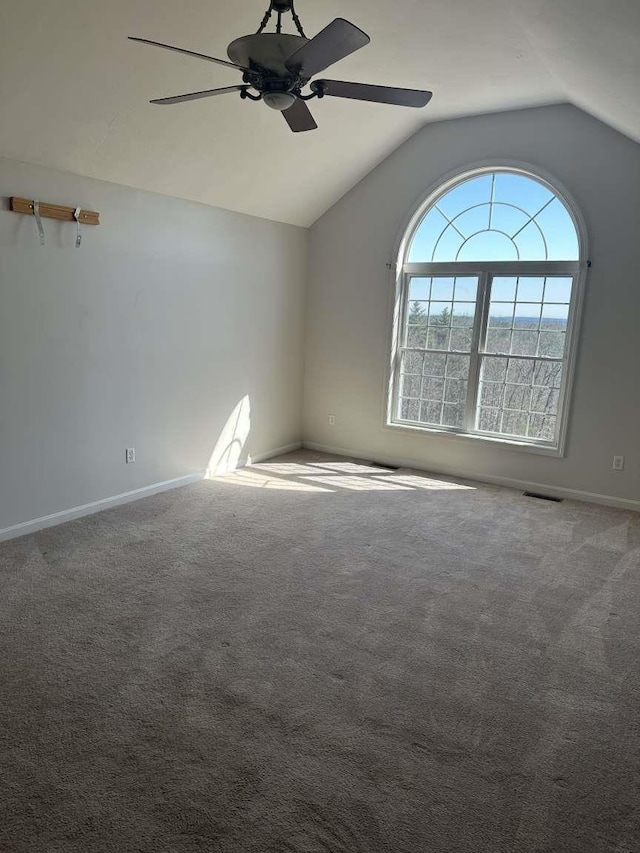 spare room with ceiling fan, lofted ceiling, baseboards, and carpet