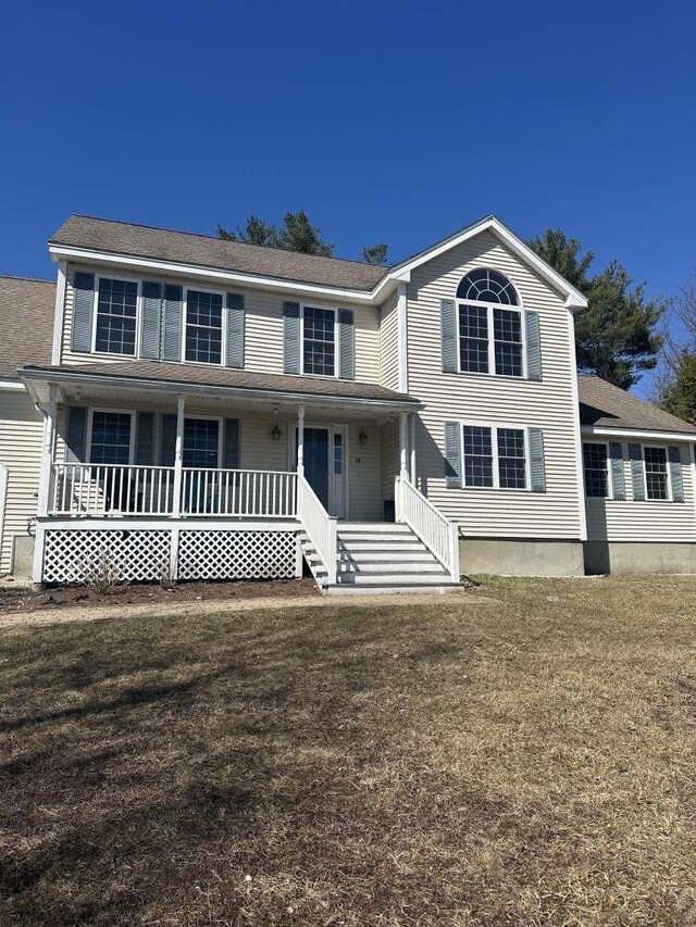 view of front of home with covered porch and a front lawn