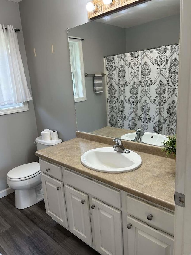 full bathroom with wood finished floors, toilet, vanity, and a shower with curtain