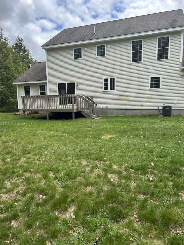 back of property featuring a deck, a lawn, and central air condition unit