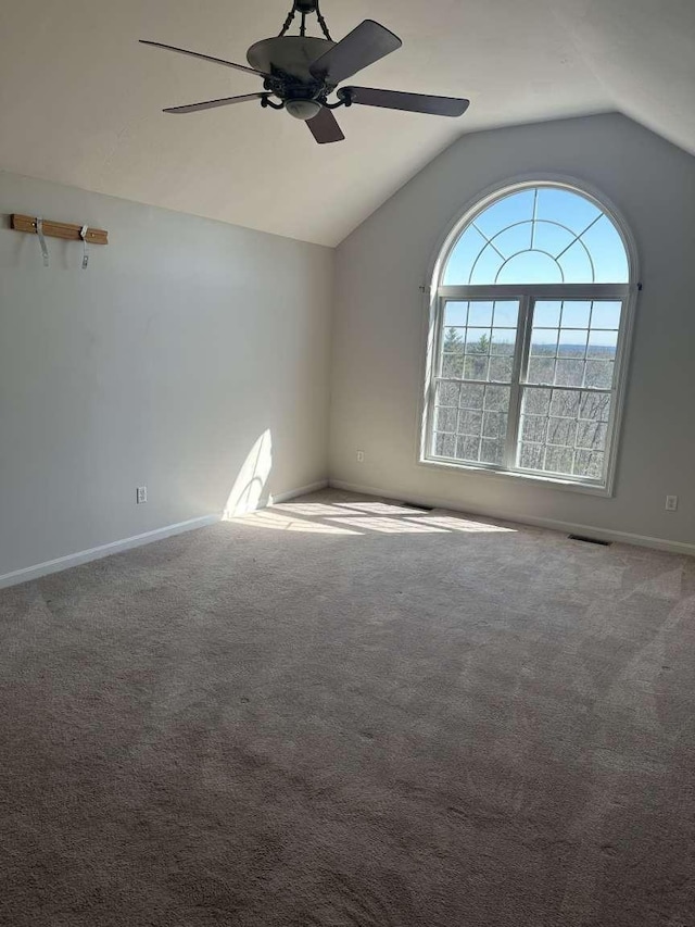 unfurnished room featuring ceiling fan, lofted ceiling, baseboards, and carpet