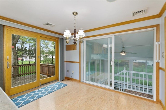 entryway featuring a chandelier, wood finished floors, crown molding, and baseboards