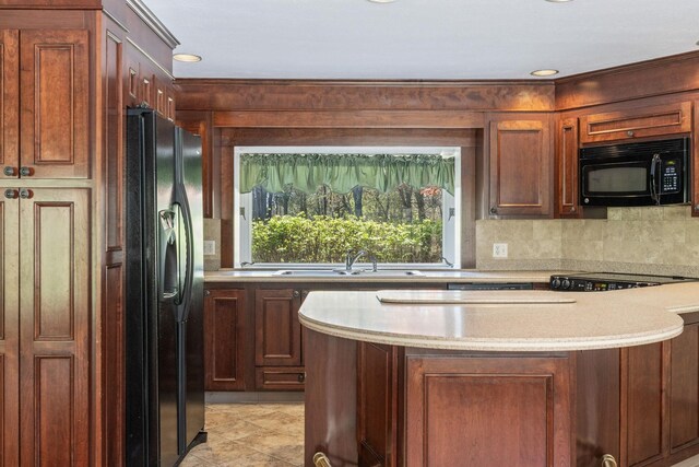 kitchen featuring black appliances, a sink, light countertops, a center island, and backsplash