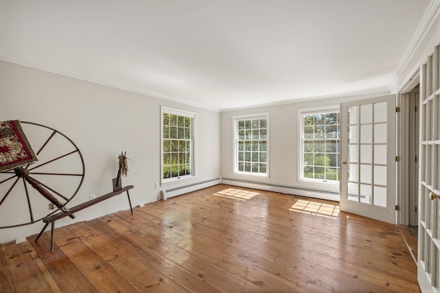 spare room with crown molding, plenty of natural light, hardwood / wood-style floors, and a baseboard radiator