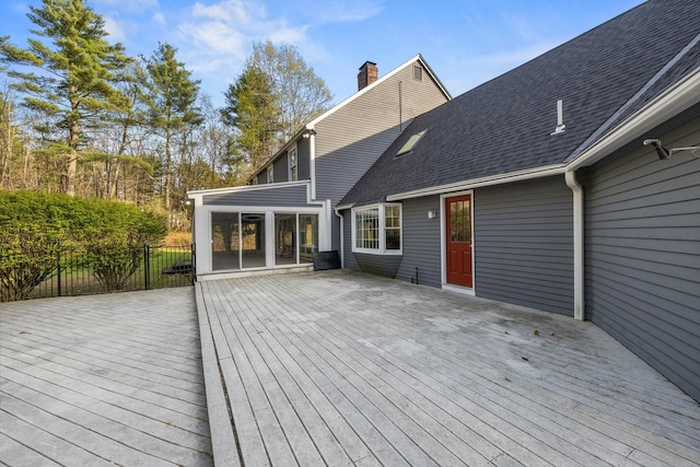 wooden terrace featuring a sunroom and fence