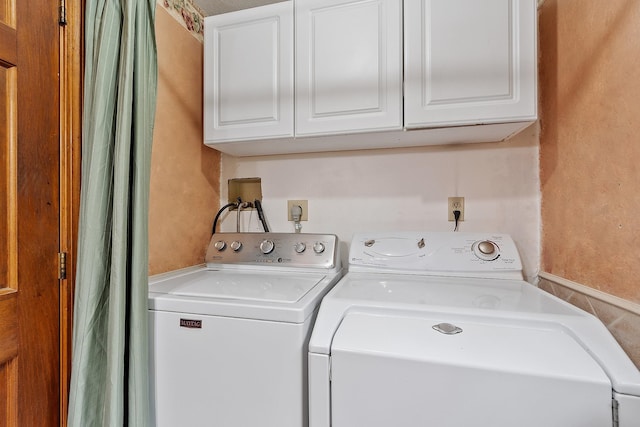washroom featuring washing machine and dryer and cabinet space