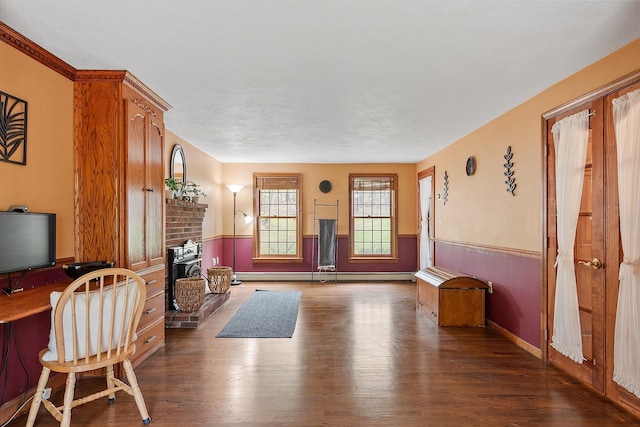 living room featuring wood finished floors, a wainscoted wall, a baseboard radiator, an office area, and baseboards