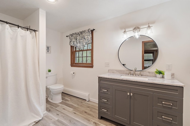 bathroom featuring a baseboard heating unit, toilet, wood finished floors, baseboards, and vanity