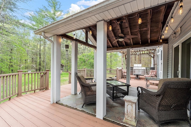 wooden deck featuring ceiling fan, an outdoor living space, and area for grilling